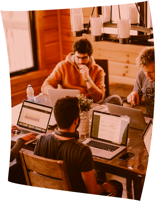 Designers working together around a table with laptops